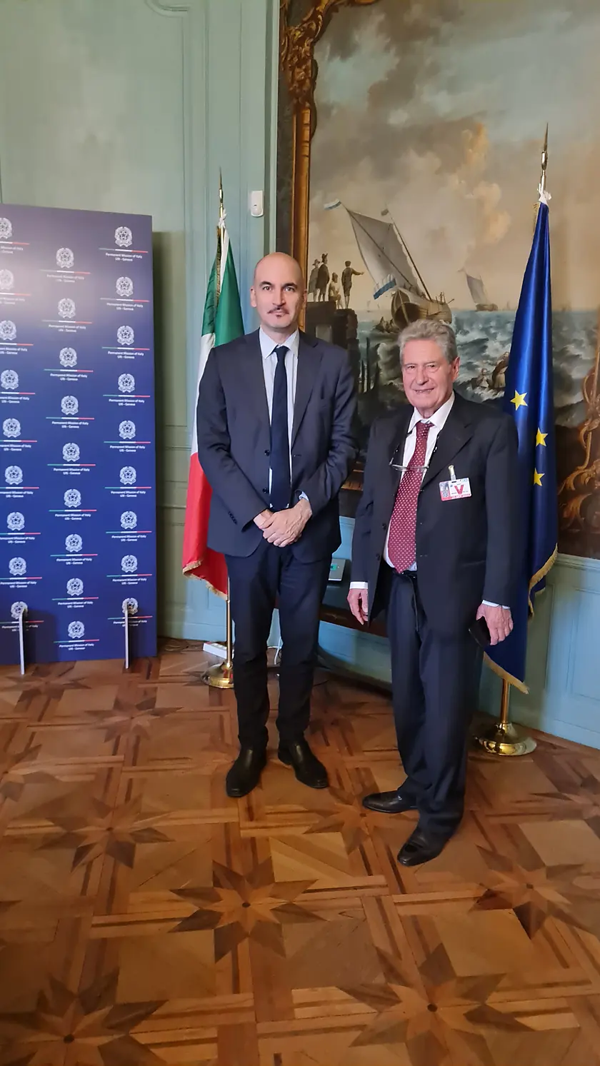 Il presidente Angelo Rojch con l’Ambasciatore Vincenzo Grassi davanti alle bandiere italiana ed europea, a Ginevra